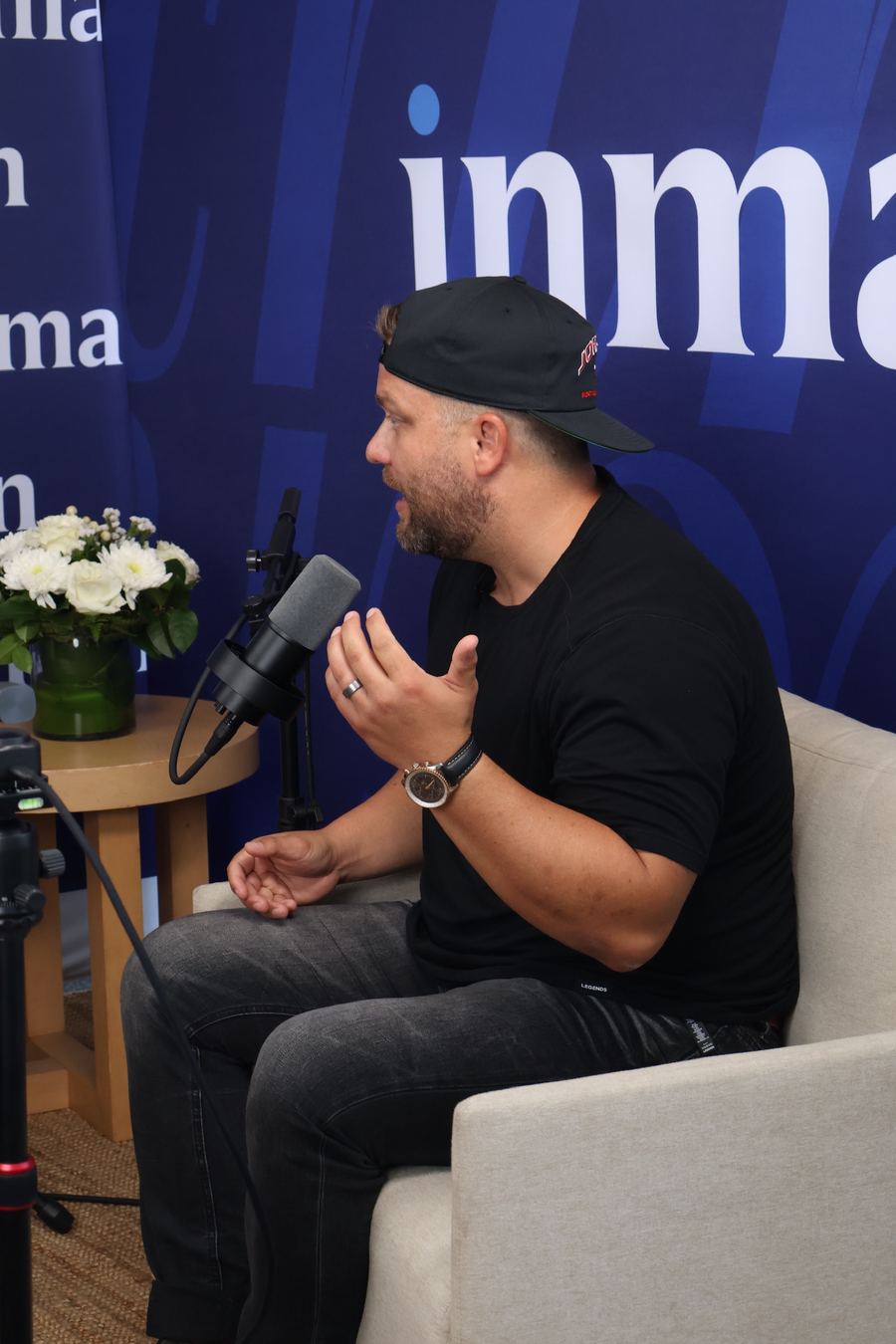 Jeremy Davis speaking into a podcast microphone in front of an Inman backdrop